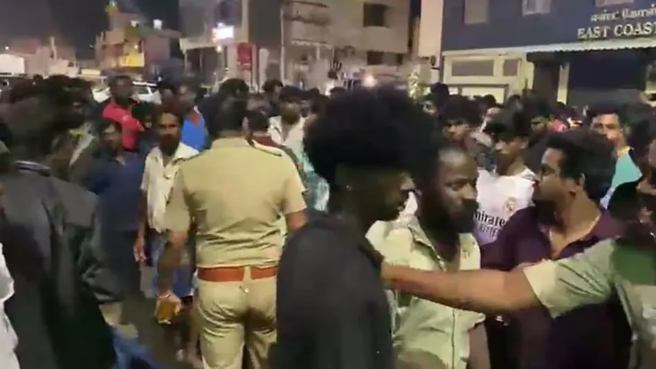 Police and a crowd on the road in Neelankarai, Chennai, after the accident that killed a 62-year-old woman.