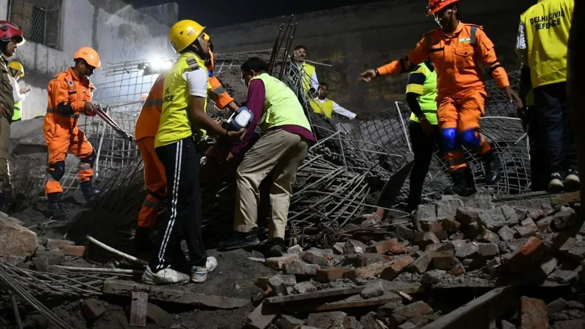 Rescue teams search the debris after the Harsh Vihar building collapse in Delhi.