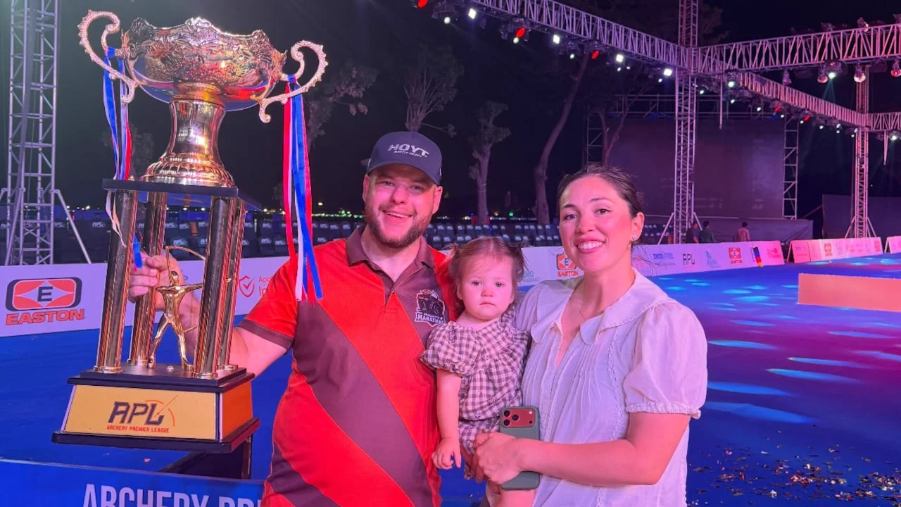 Mike and Gaby Schloesser with daughter Luna and the Archery Premier League trophy